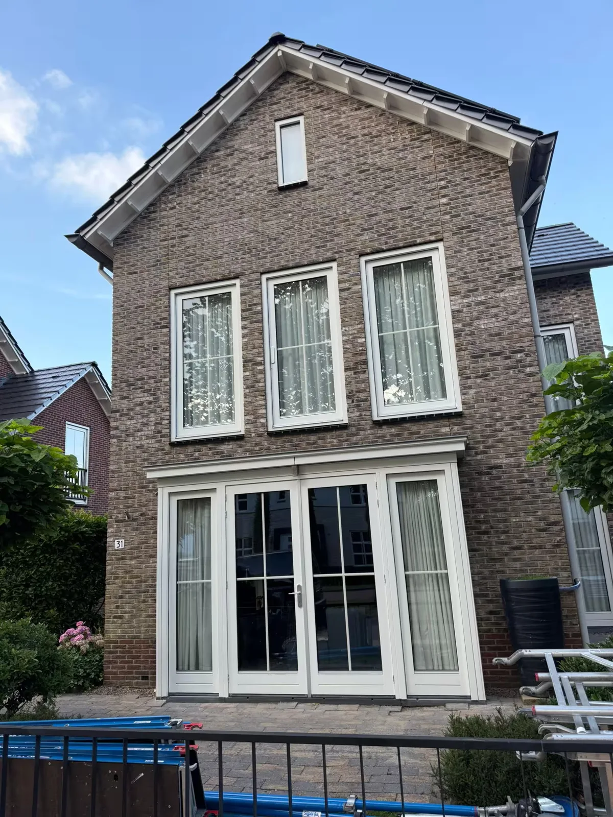 Bakstenen woning met witte kozijnen en verzorgd buitenhoutwerk